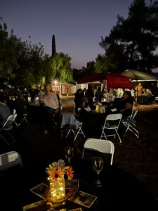 Picture of tables and chairs set up at night at the ranch